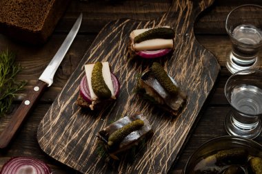 Pastırma ve karanlık bir arka plan üzerine votka için çerez olarak ringa balığı ile Mini sandviç