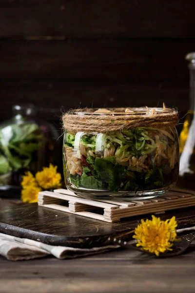 Салат из проросшей сои и листьев одуванчика в банке — стоковое фото