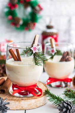 Geleneksel eggnog Noel kokteyli. Yeni yıl mandallarıyla süslenmiş cam bir kadehte. Alkolsüz seçenek.