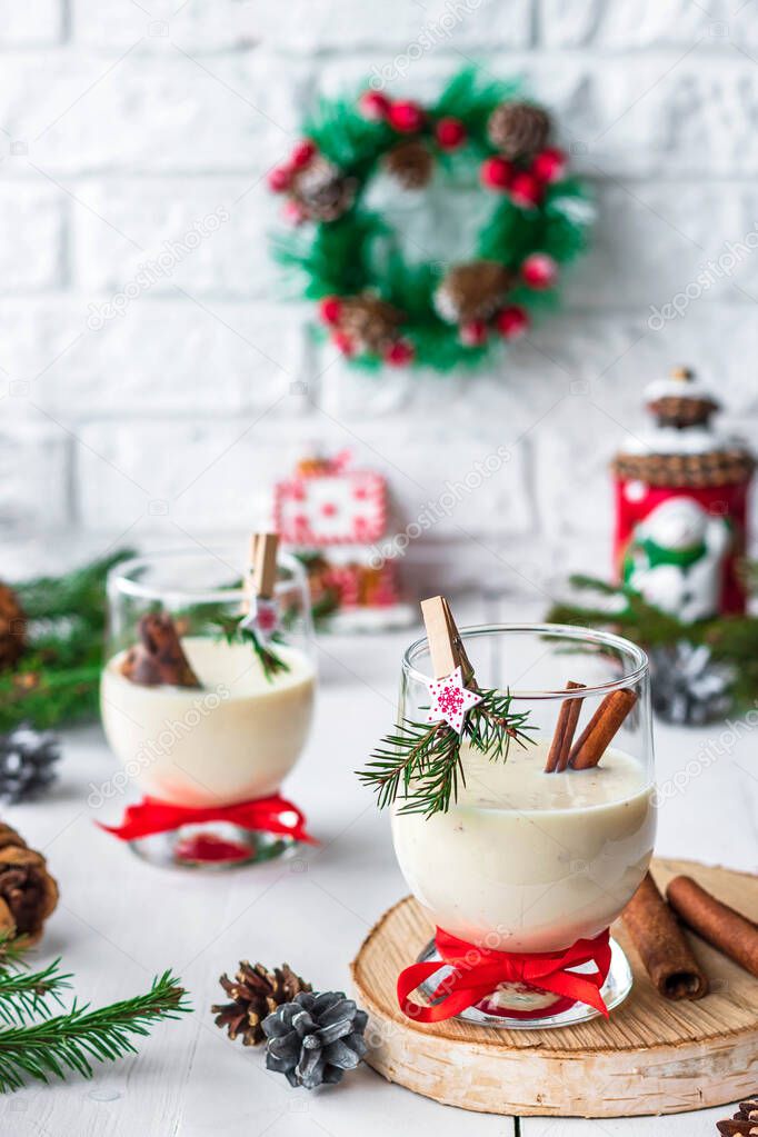 Traditional eggnog Christmas cocktail in a glass goblet decorated with New Year clothespin. Non-alcoholic option.