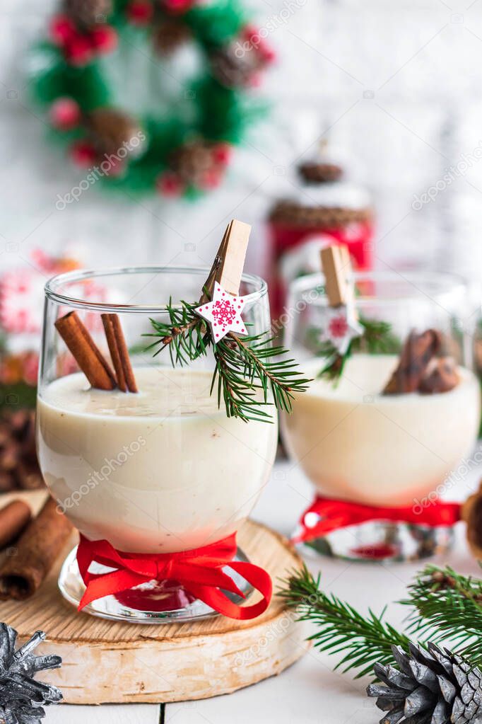 Traditional eggnog Christmas cocktail in a glass goblet decorated with New Year clothespin. Non-alcoholic option.