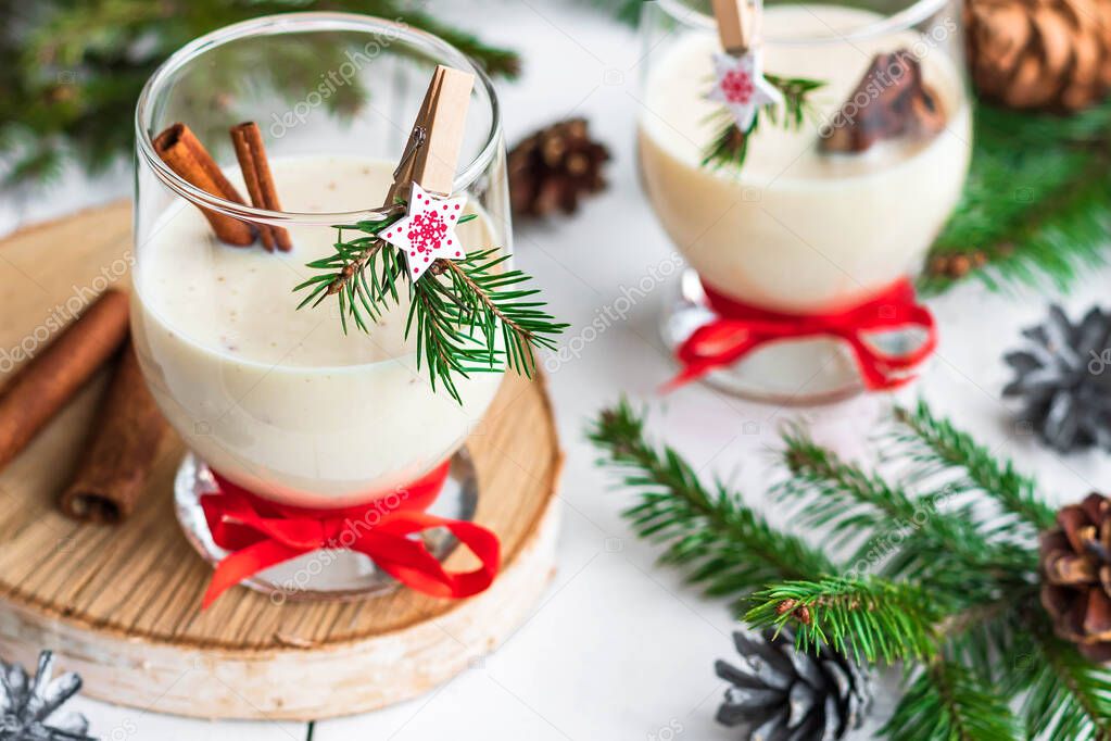 Traditional eggnog Christmas cocktail in a glass goblet decorated with New Year clothespin. Non-alcoholic option.