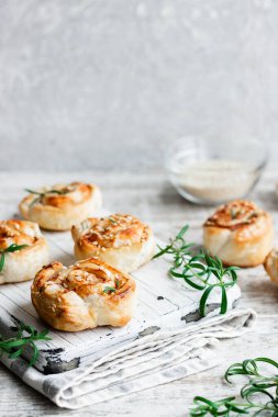 Unsweetened snails and puff pastry with bacon, sesame seeds and rosemary.