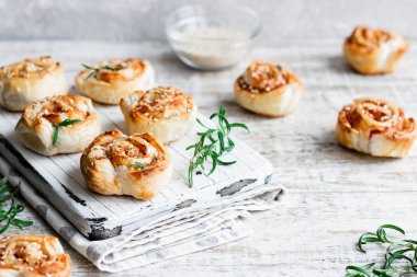 Unsweetened snails and puff pastry with bacon, sesame seeds and rosemary.