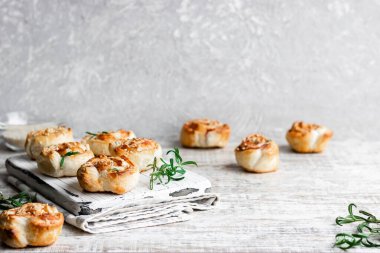 Unsweetened snails and puff pastry with bacon, sesame seeds and rosemary.