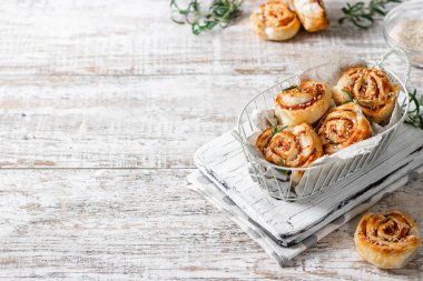 Unsweetened snails and puff pastry with bacon, sesame seeds and rosemary.