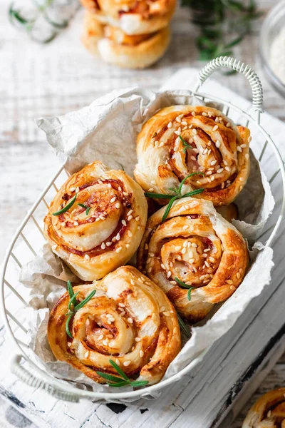 Unsweetened snails and puff pastry with bacon, sesame seeds and rosemary.