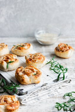 Unsweetened snails and puff pastry with bacon, sesame seeds and rosemary.