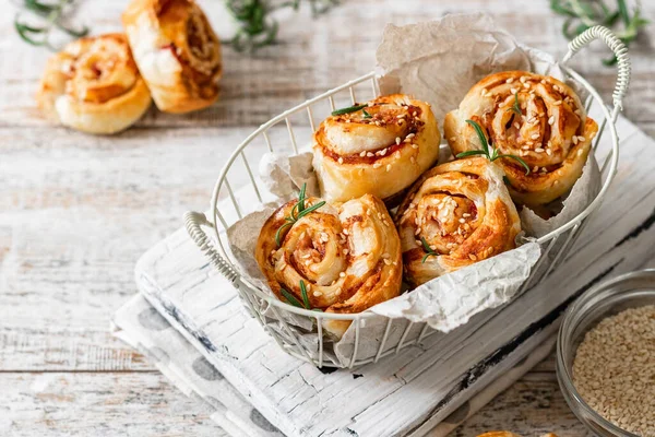 Unsweetened snails and puff pastry with bacon, sesame seeds and rosemary.