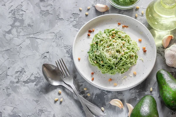 Green pasta with avocado, spinach and pine nuts