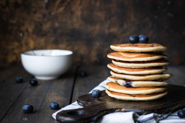 ricotta krepleri koyu ahşap arka planda yaban mersinli.