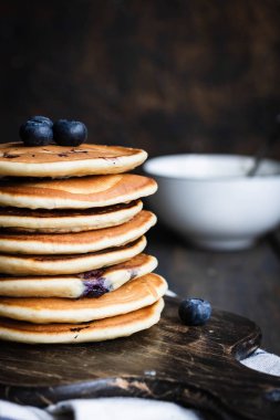 ricotta krepleri koyu ahşap arka planda yaban mersinli.