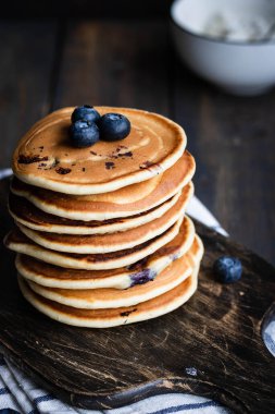 ricotta krepleri koyu ahşap arka planda yaban mersinli.