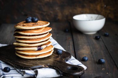ricotta krepleri koyu ahşap arka planda yaban mersinli.
