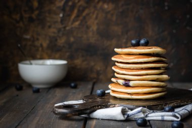 ricotta krepleri koyu ahşap arka planda yaban mersinli.