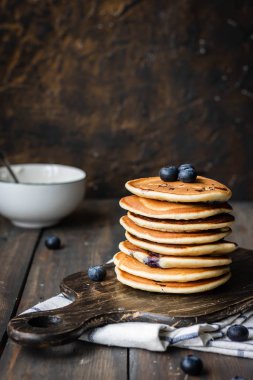 ricotta krepleri koyu ahşap arka planda yaban mersinli.