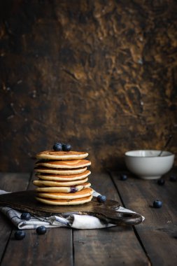 ricotta krepleri koyu ahşap arka planda yaban mersinli.