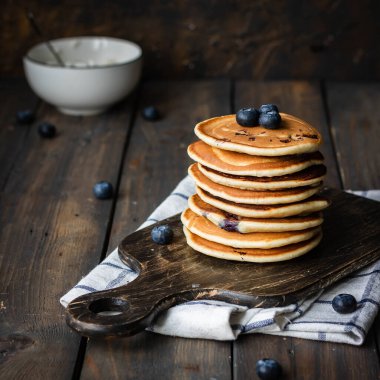 ricotta krepleri koyu ahşap arka planda yaban mersinli.