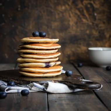 ricotta krepleri koyu ahşap arka planda yaban mersinli.