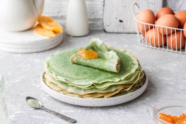 Yeşil krep, kibrit çayı ve mango reçeli. Süslü krepler. Shrovetide 'de krep