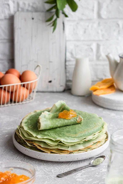 Yeşil krep, kibrit çayı ve mango reçeli. Süslü krepler. Shrovetide 'de krep