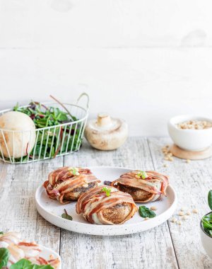 Peynirle doldurulmuş büyük mantarlar ve domuz pastırmasında pişmiş çam fıstığı. Güzel ve renkli bayram atıştırmalıkları. Yemek servisi için tabak..