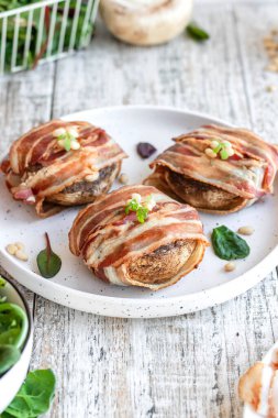 Peynirle doldurulmuş büyük mantarlar ve domuz pastırmasında pişmiş çam fıstığı. Güzel ve renkli bayram atıştırmalıkları. Yemek servisi için tabak..
