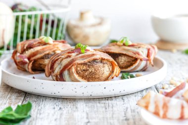 Peynirle doldurulmuş büyük mantarlar ve domuz pastırmasında pişmiş çam fıstığı. Güzel ve renkli bayram atıştırmalıkları. Yemek servisi için tabak..