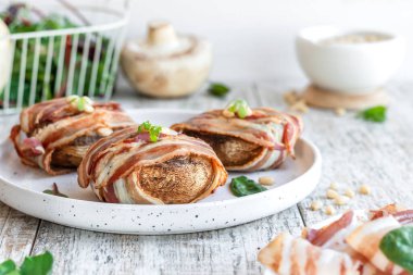Peynirle doldurulmuş büyük mantarlar ve domuz pastırmasında pişmiş çam fıstığı. Güzel ve renkli bayram atıştırmalıkları. Yemek servisi için tabak..