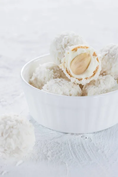 Candies with nougat and almonds in coconut flakes on a light background — Stock Photo, Image