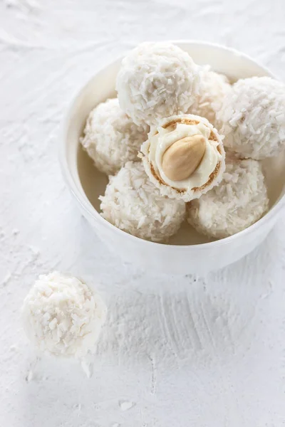 Bonbons au nougat et amandes en flocons de noix de coco sur fond clair — Photo