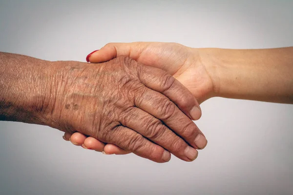 Jeunes et vieux femmes tenant la main — Photo