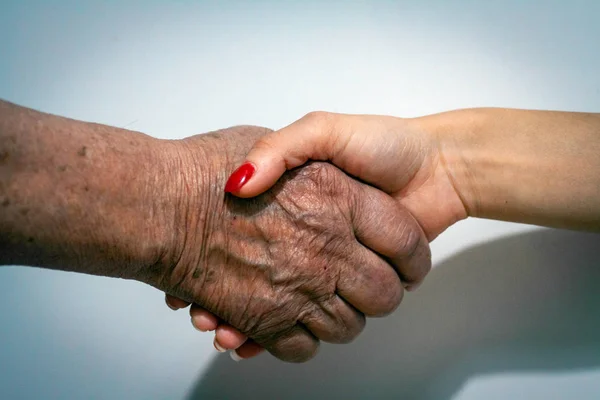 Old and Young Women Holding Hands