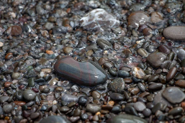 Galets de mer granit coloré sur la plage pierres de fond. — Photo