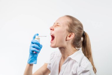 Genç ve çekici bir doktor. Boğazına sprey sıkılmış.