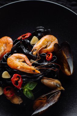 Taze karides ve üzerinde siyah makarna midye