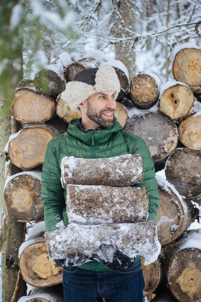 Homem segurando lenha e sorrindo — Fotografia de Stock