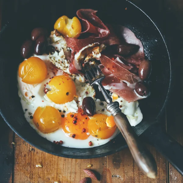 Frying pan of eggs and meat with tomatoes — Stock Photo, Image