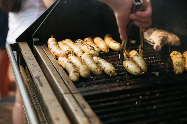 Chef cooking sausages on grill — Stock Photo, Image