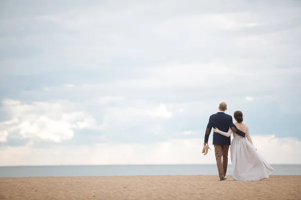 Pareja casada caminando en la playa — Foto de Stock