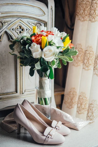 Hoge hakken schoenen en bruiloft boeket — Stockfoto
