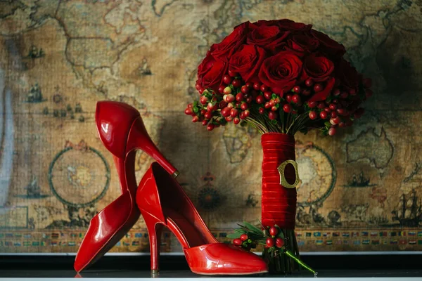 Red wedding bouquet and pair of heels — Stock Photo, Image