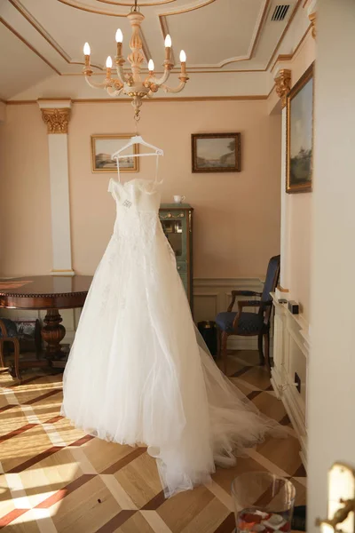 Свадебное платье висит в комнате Стоковое Фото