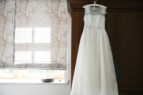 Свадебное платье висит в комнате Стоковое Изображение