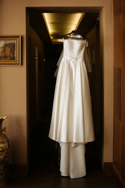 Свадебное платье висит в комнате Лицензионные Стоковые Изображения
