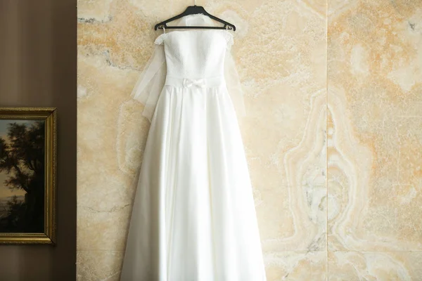 Свадебное платье висит на стене Стоковое Изображение