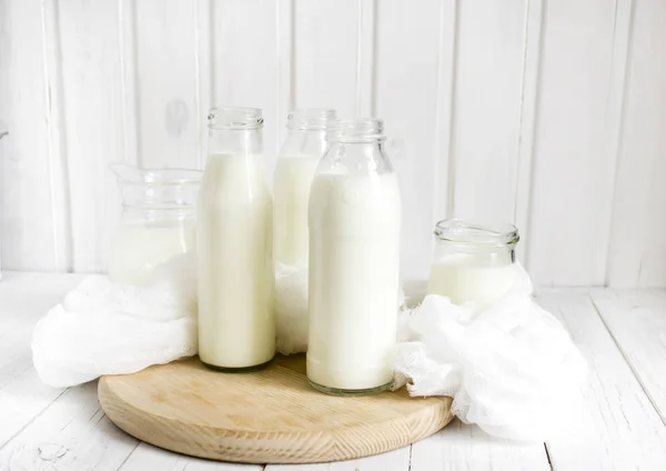 Lait frais en bouteilles de verre sur fond bois clair — Photo