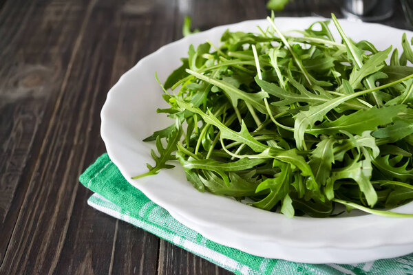 Fresh juicy arugula on a white plate