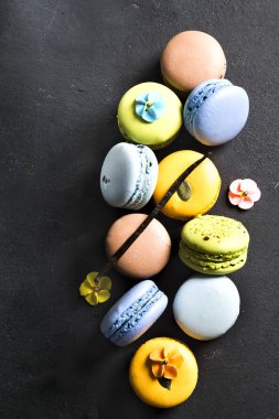 Siyah bir zemin üzerine çeşitli renkli Fransız çerezleri macaroons.
