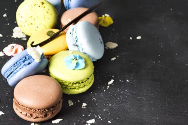 Siyah bir zemin üzerine çeşitli renkli Fransız çerezleri macaroons.